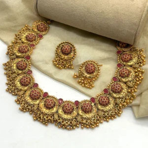 Gold plated South Indian choker necklace set with earrings featuring red stones and temple jewelry design.
